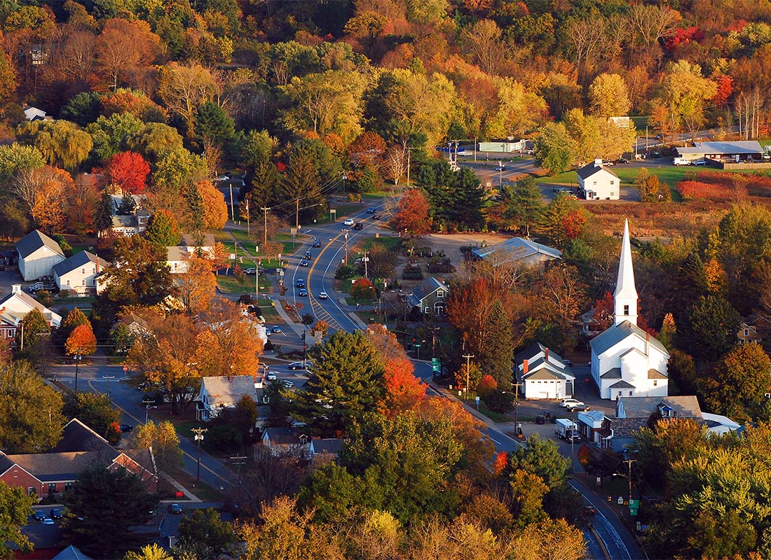 Whitinsville, MA - Aerial View of Homes and Buildings Surrounded by Colorful Fall Trees in Whitinsville Massachusetts