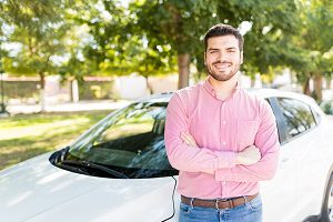 man leaning on car smiling at camera