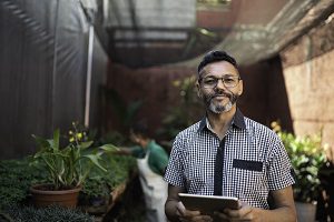 business owner smiling at camera holding a tablet